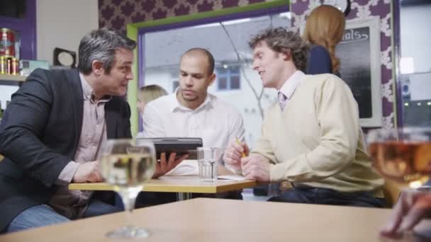 Three cheerful businessmen in casual meeting in a cafe — Stock Video