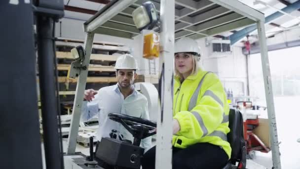 Femme conducteur de chariot élévateur commence son quart dans une usine ou un entrepôt — Video