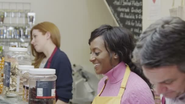 Přátelské lahůdky personál bude obsluhovat zákazníky s úsměvem na sýr čítače — Stockvideo