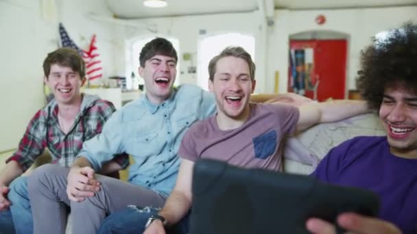 Happy casual group of young male friends relaxing with a tablet computer — Stock Video