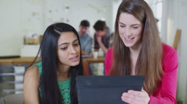 iki genç kız öğrenci bir bilgisayar tablet ile birlikte çalışma