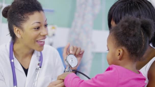 Female doctor checking the blood pressure of a cute little girl in hospital — Stock Video