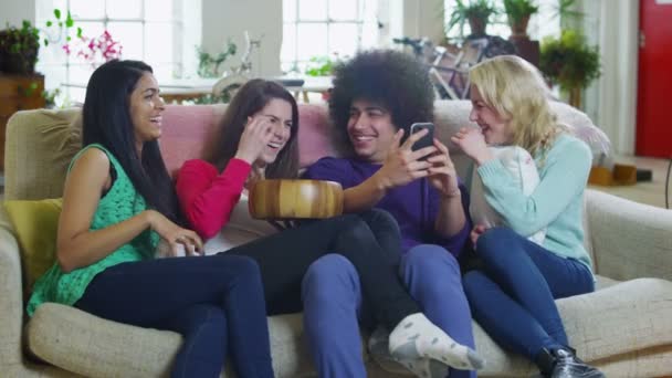 Счастливая разносторонняя группа молодых друзей, тусующихся дома и смеющихся вместе — стоковое видео