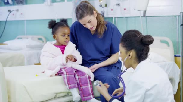 Medico femminile utilizza uno stetoscopio per esaminare carina bambina in ospedale . — Video Stock