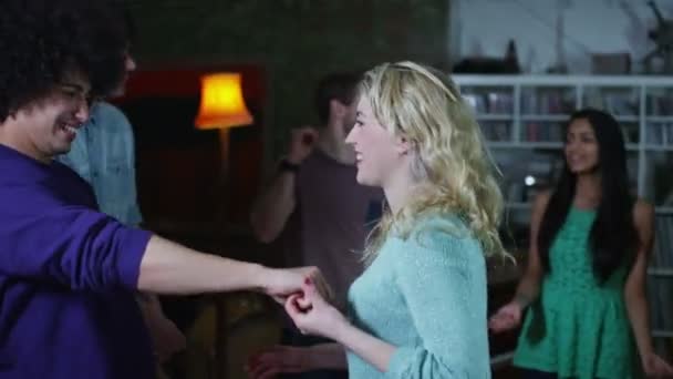 Gelukkig en zorgeloze groep van jonge vrienden dansen en flirten op een house party — Stockvideo