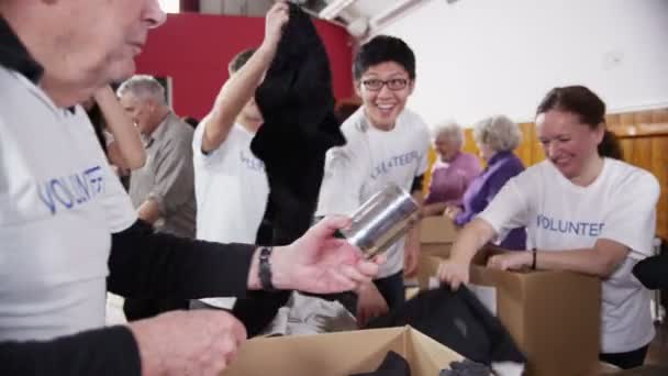 Voluntarios de caridad de todas las edades disfrutan de una risa y una broma juntos — Vídeos de Stock