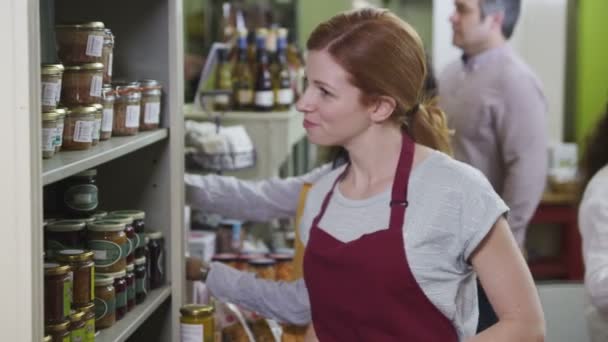 Customers and staff members in a small friendly delicatessen or food store — Stock Video