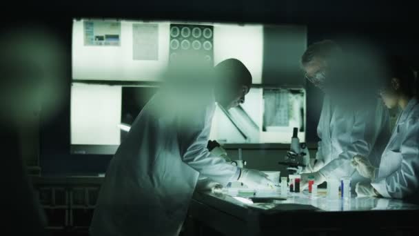 sötét laboratóriumban dolgozó tudósok