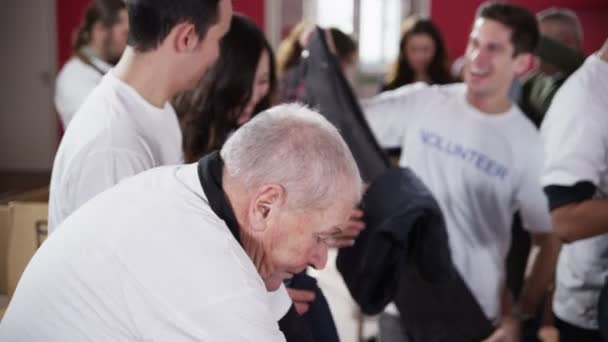 Charity volunteers in white printed t. shirts sorting through donated clothing — Stock Video