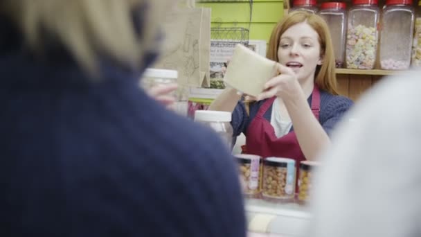 Equipe delicatessen amigável que serve os clientes com um sorriso no balcão de queijo — Vídeo de Stock