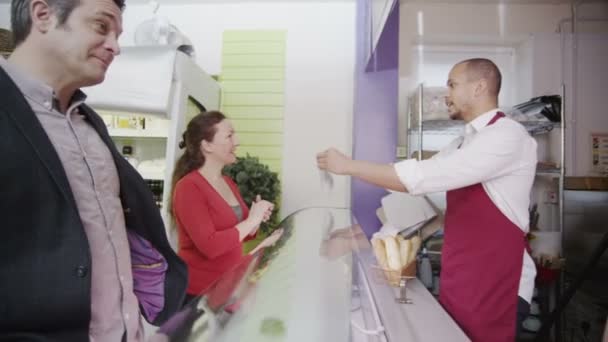 Equipe amigável que serve clientes com um sorriso no balcão da padaria — Vídeo de Stock