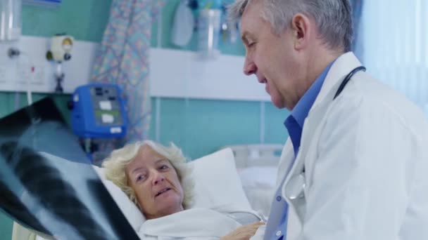 Врач обсуждает результаты рентгена с пациентом — стоковое видео
