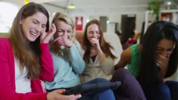 Feliz casual jovens amigas rindo do que eles vêem em um tablet de computador — Vídeo de Stock