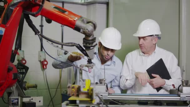 성숙한 남성 공장 관리자 젊은 사람에 게는 기계 작동 하는 방법 설명 — 비디오