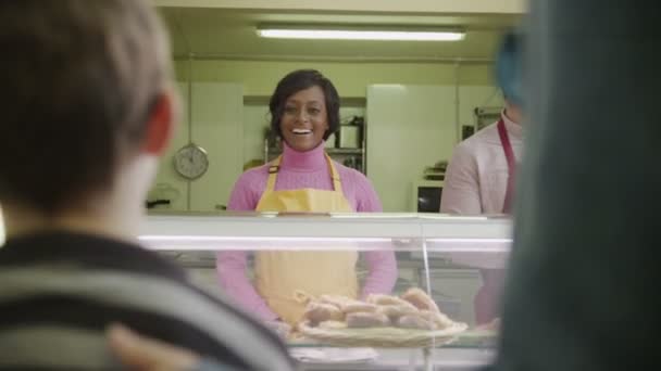 Amable tendero sirviendo a los clientes con pasteles frescos — Vídeos de Stock