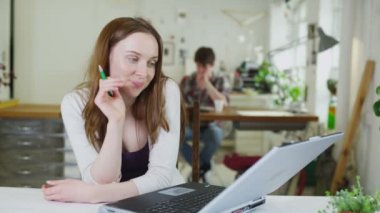 Paylaşılan çalışma alanı işinde genç kız öğrencinin dikkati dağınık