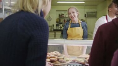 güler yüzlü personel ekmek sayaç bir gülümseme ile müşterilerine hizmet