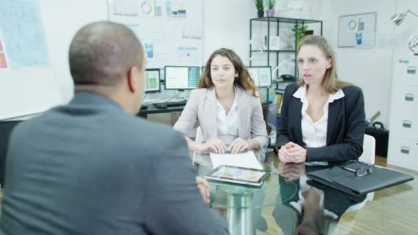 Empresário em uma reunião dá boas notícias para dois de seus funcionários — Vídeo de Stock