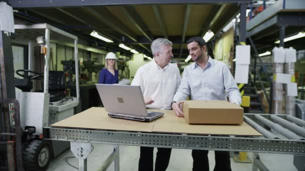 Arbeiter in einem Lager mit einem Laptop bereiten Waren für die Auslieferung vor — Stockvideo