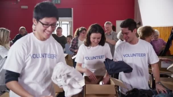 Caridade voluntários triagem através de bens doados — Vídeo de Stock