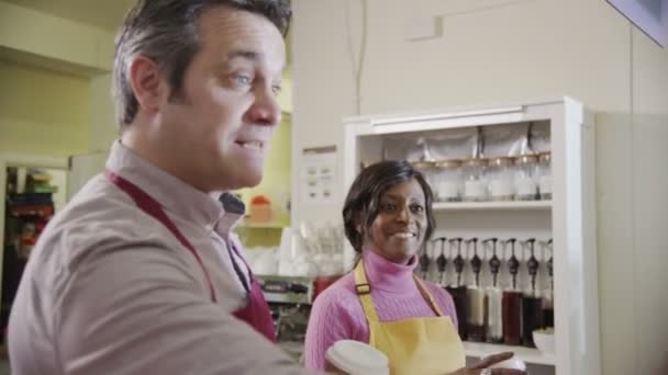 Amistosos baristas masculinos y femeninos que sirven a los clientes en una cafetería — Vídeos de Stock