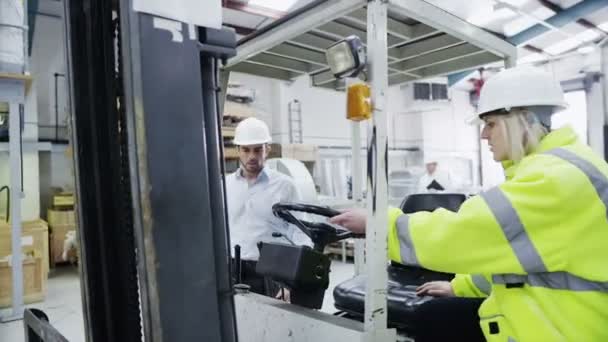 Kvinnliga gaffeltruck förare börjar sin SKIFT i en fabrik eller lager — Stockvideo