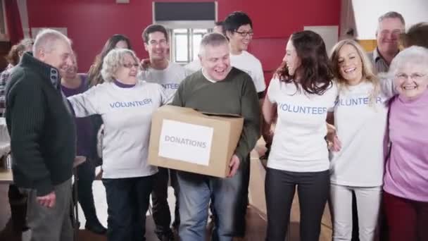 Gran grupo de voluntarios de caridad abrazan y dan grandes sonrisas en la cámara — Vídeos de Stock
