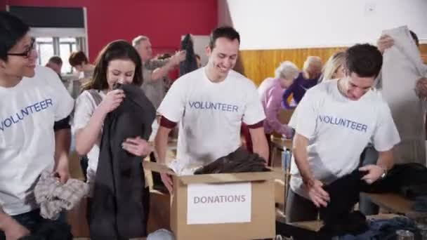 Charity volunteers sorting through donated goods — Stock Video