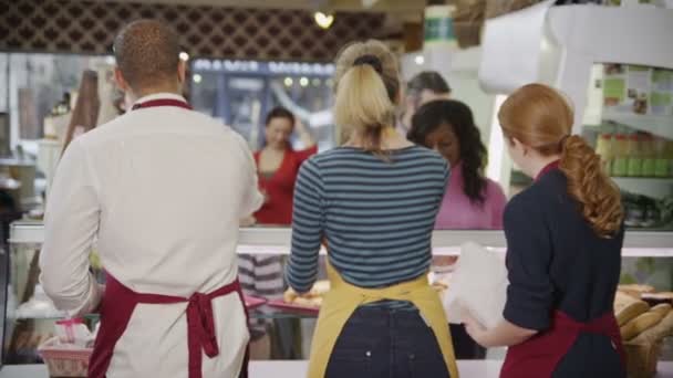 Счастливых клиентов обслуживает дружелюбный персонал в булочной — стоковое видео