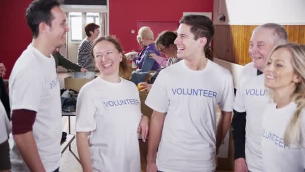 Happy circle of volunteers put their hands together in a show of unity — Stock Video
