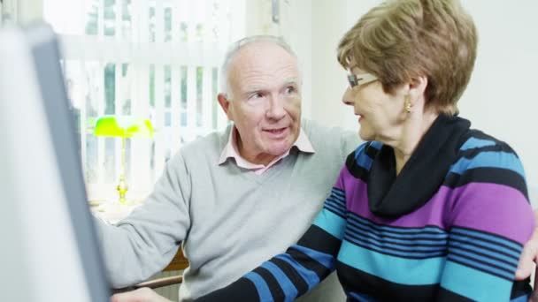 An elderly couple are browsing the internet together — Stock Video