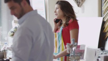 Mağaza sahibi telefon iş yapar.