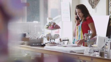 Mağaza sahibi telefon iş yapar.