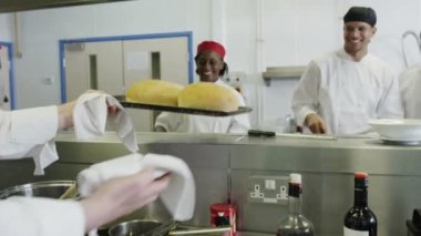 Olgun erkek aşçı tepsi taze pişmiş ekmek tutan