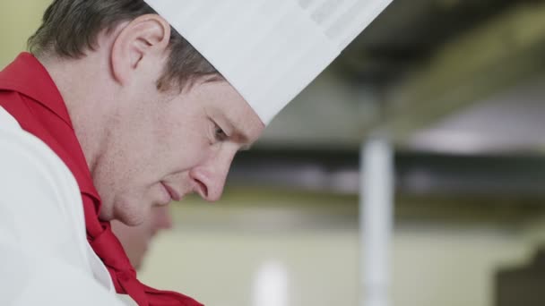 Professionele chef-kok in een commerciële keuken te concentreren op zijn werk — Stockvideo