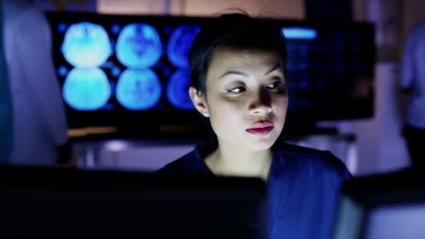 Profissional de saúde feminino trabalhando até tarde na frente de uma tela de computador — Vídeo de Stock