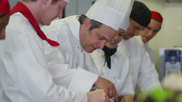 Equipe de chefs profissionais trabalhando juntos em uma cozinha comercial — Vídeo de Stock