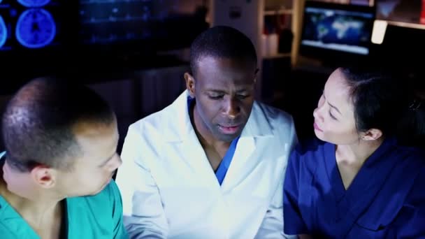 Diverse group of medical professionals working together late into the night — Stock Video