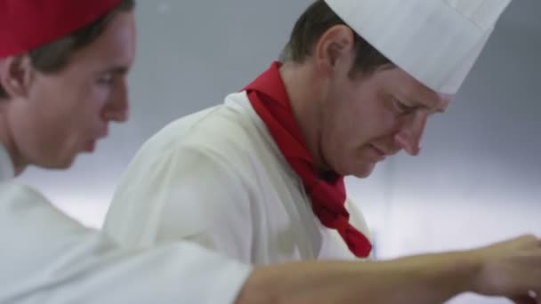 Kuchaři připravují jídlo v komerční kuchyni — Stock video