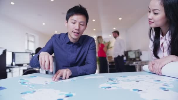 Global Business Team untersucht eine Weltkarte — Stockvideo