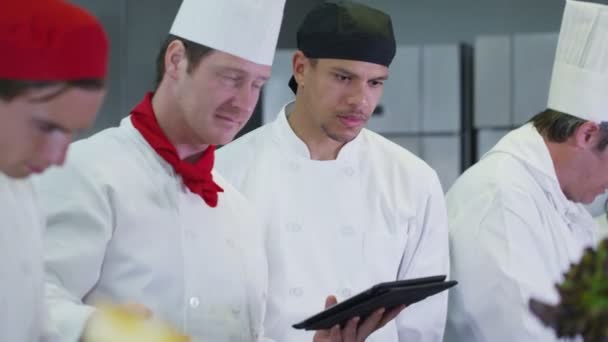 Chefs profesionales organizando su horario en un restaurante o cocina de hotel — Vídeos de Stock