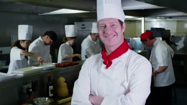 Retrato del jefe de cocina sonriente y su personal en una cocina comercial — Vídeos de Stock