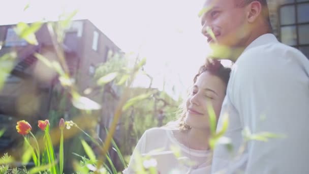 Young couple embrace in garden — Stock Video