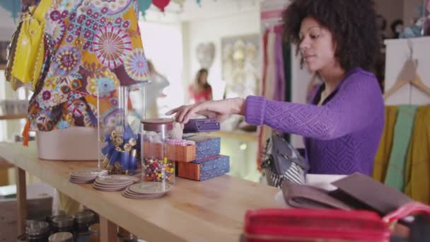 Mulher olha para a bolsa no balcão — Vídeo de Stock