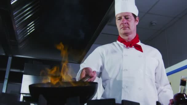 Professional chef in a commercial kitchen cooking flambe style. — Stock Video