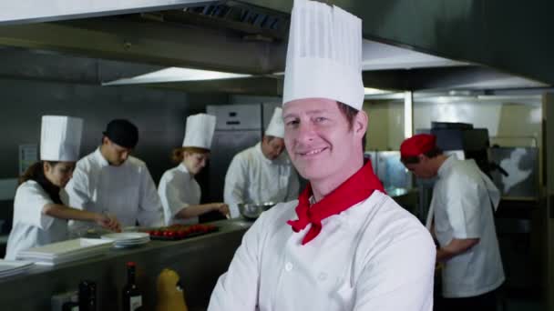 Porträt eines lächelnden Küchenchefs und seiner Mitarbeiter in einer Großküche — Stockvideo