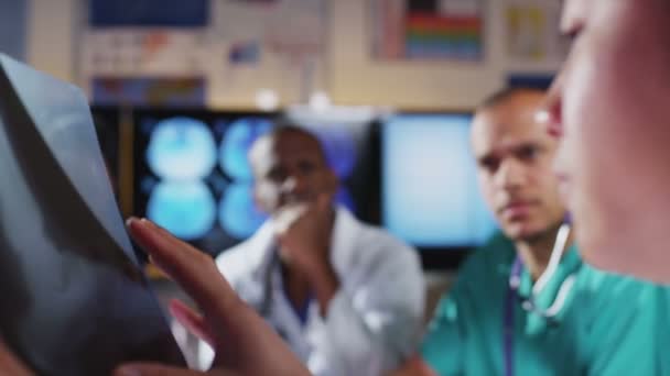 Grupo de colegas en una reunión médica discuten la radiografía y las exploraciones de un paciente — Vídeo de stock