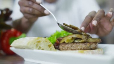 Lezzetli gurme burger rötuşları Şef tarafından verilmektedir