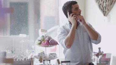 Mağaza sahibi telefon iş yapar.