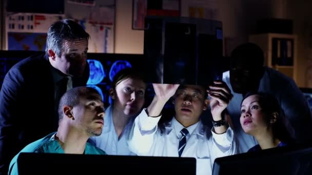 Разнообразная группа медицинских работников, работающих вместе до поздней ночи — стоковое видео